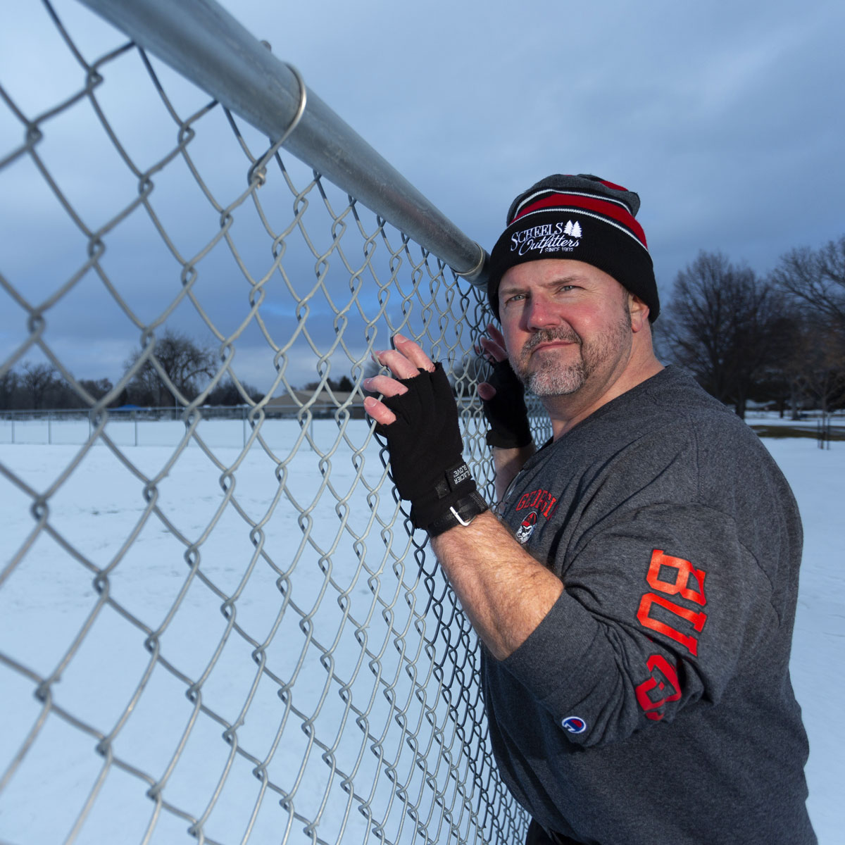 in this photo a chain linke fence leads from left to right to the subject placed in the right third of the image. The snow covered background has a cool blue tint while the subject is lit with a warmer colored flash.