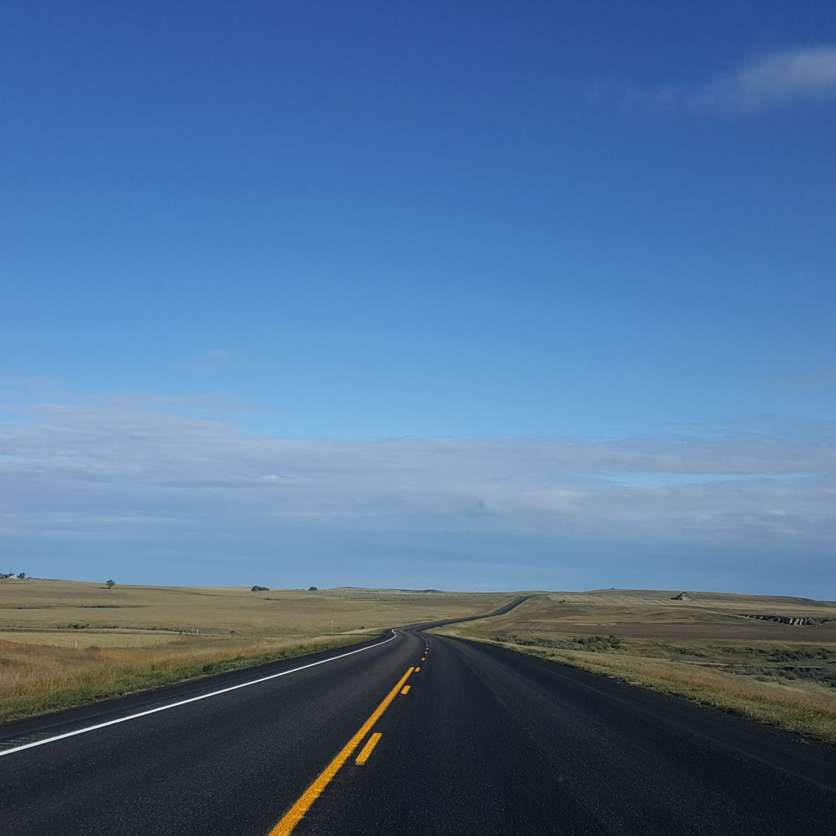 Though the open prairie in this image gives little clue to the vastness of the land the highway leading into the distance for miles gives the viewer that sense of depth and scale.