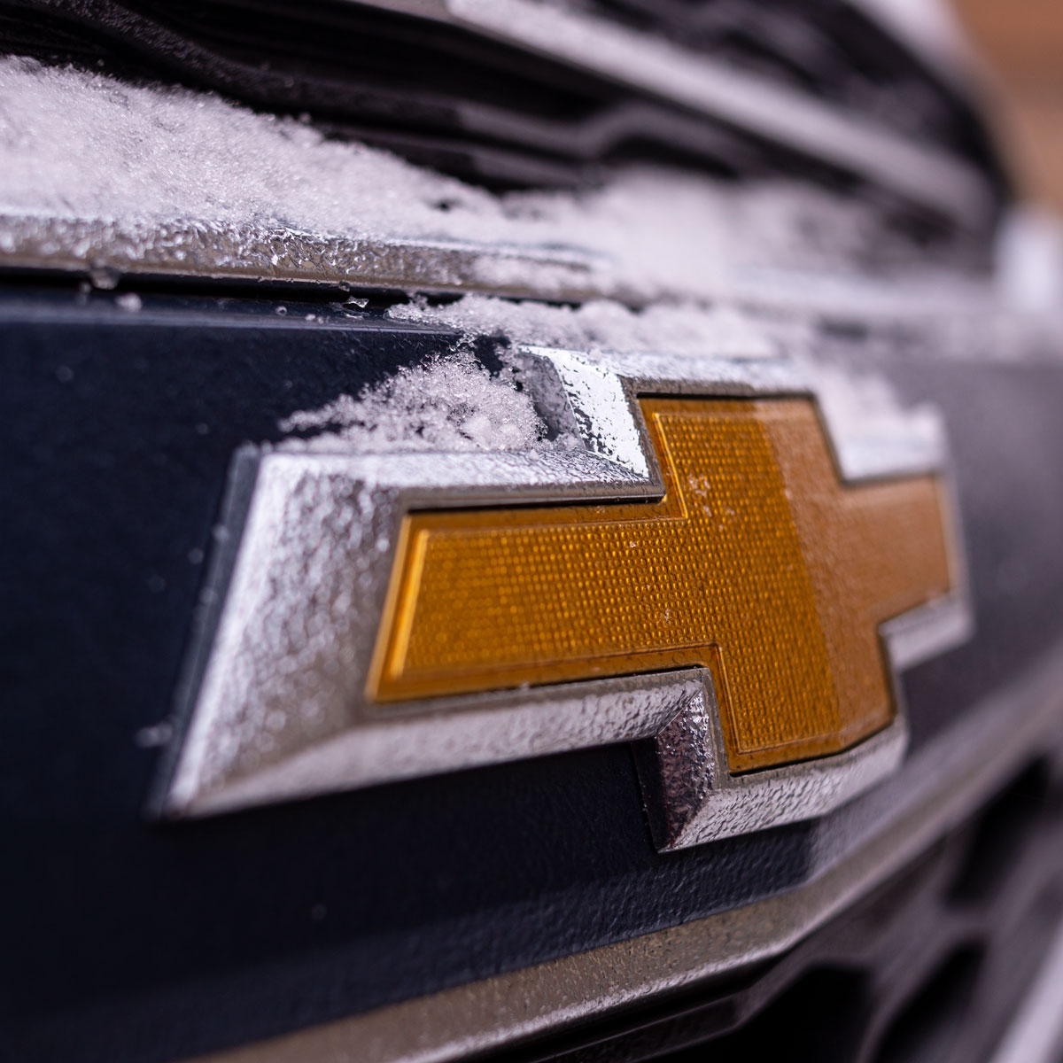 Isolating just the bow tie in this image, rather than the entire front of the car, makes it obvious what the main subject is and a bit of snow gives a hint of seasons.