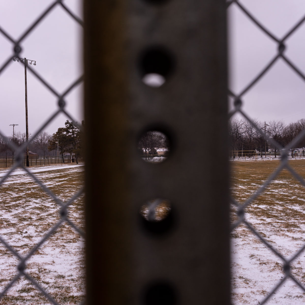 The hole is this sign post frames a view to the background creating a framing effect that makes an ordinary scene rather extraordinary.