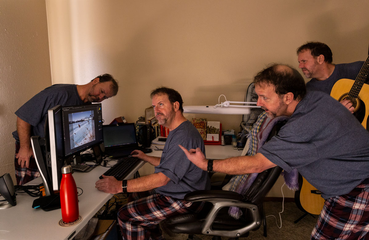 Myself and my three clones, courtesy of Photoshop, huddled around a computer monitor.